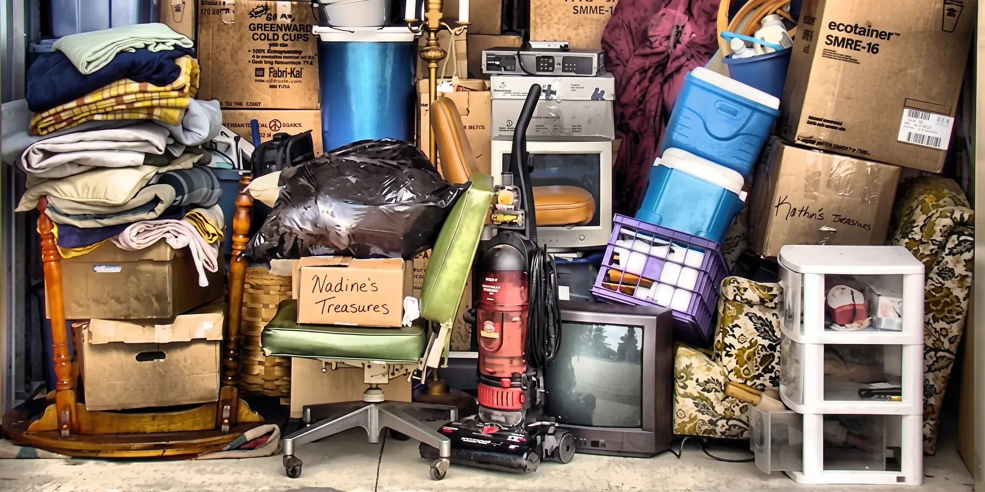 A room stacked floor to ceiling with boxes, furniture and household things waiting to be cleared